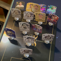 Collection of trading cards on a stand with various designs and numbers.